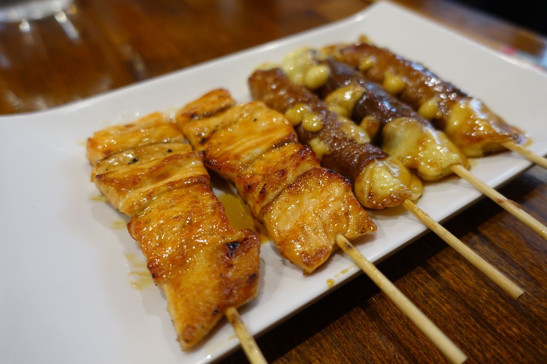 Chicken thigh skewers grilling over charcoal